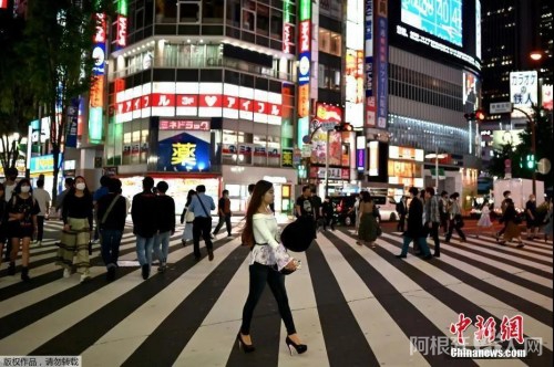 资料图：5月15日，日本解除紧急事态宣言，人们穿过东京新宿区的一条街道。（中新网）